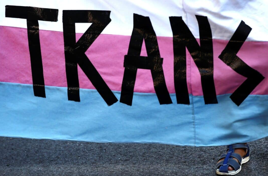 A person holds a “Trans” banner in this illustration photo. After a recent change in their admissions policy resulted in a “sense of division” in its community, St. Mary’s College in Indiana has reversed course and returned to its former policy. The now former policy, which had been approved in June, read, “St. Mary’s considers admission for undergraduate applicants whose sex is female or who consistently live and identify as women.” (OSV News photo/Sergio Perez, Reuters)